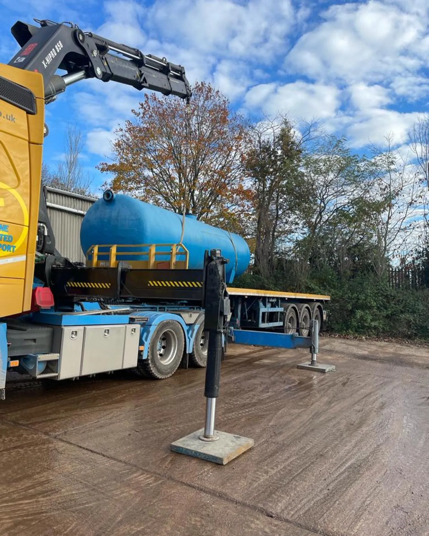 A blue and yellow truck parked next to a parking meter.