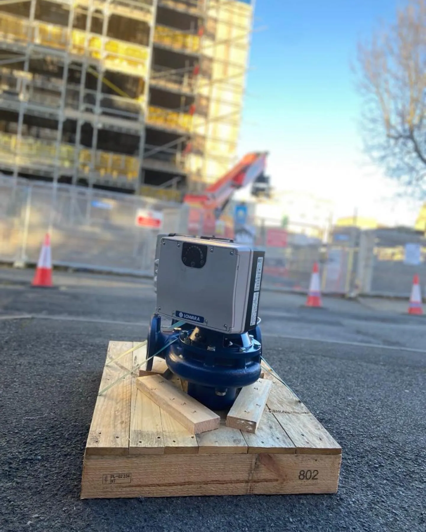 A blue machine is sitting on a piece of wood.