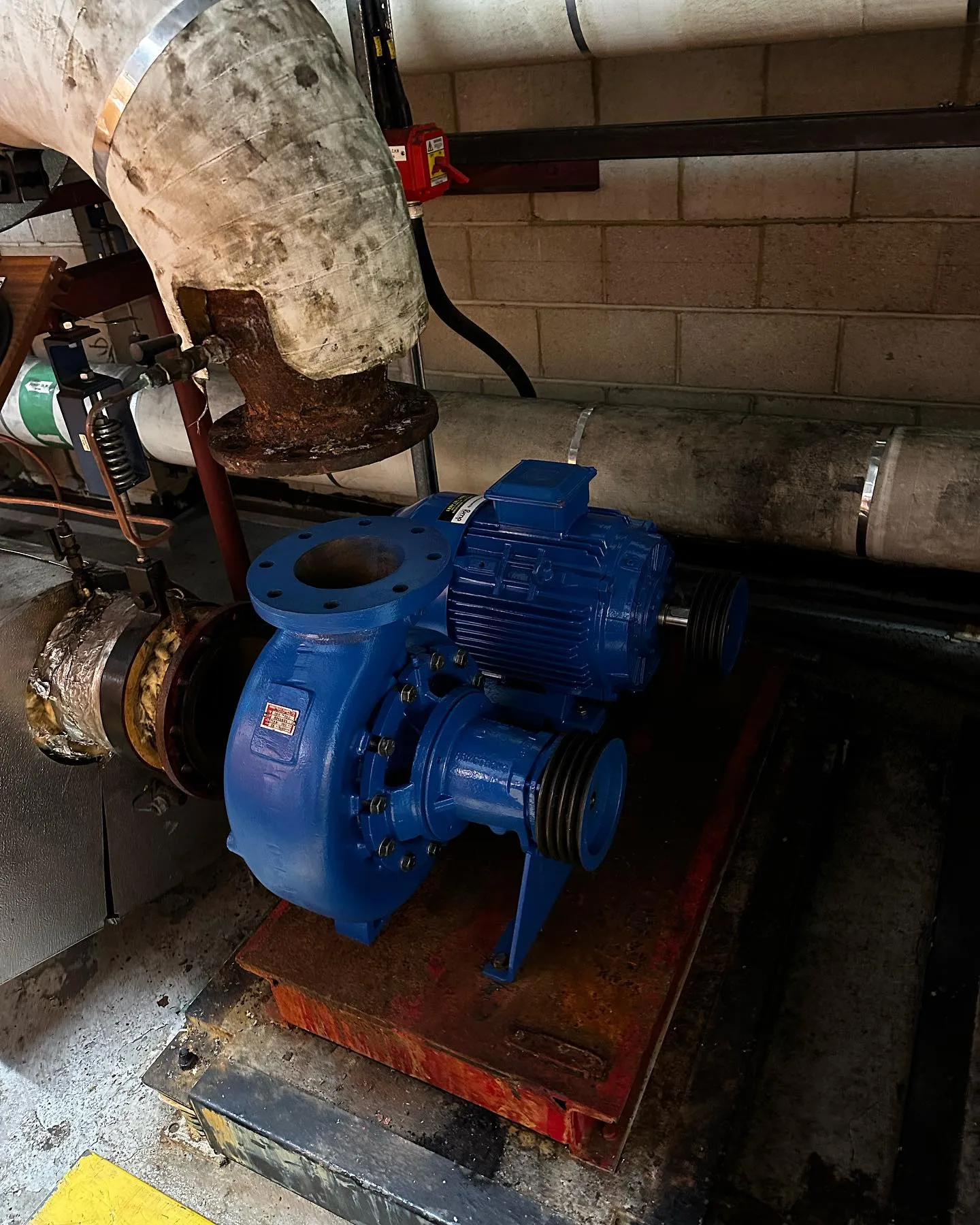 A blue machine is sitting on a piece of wood.