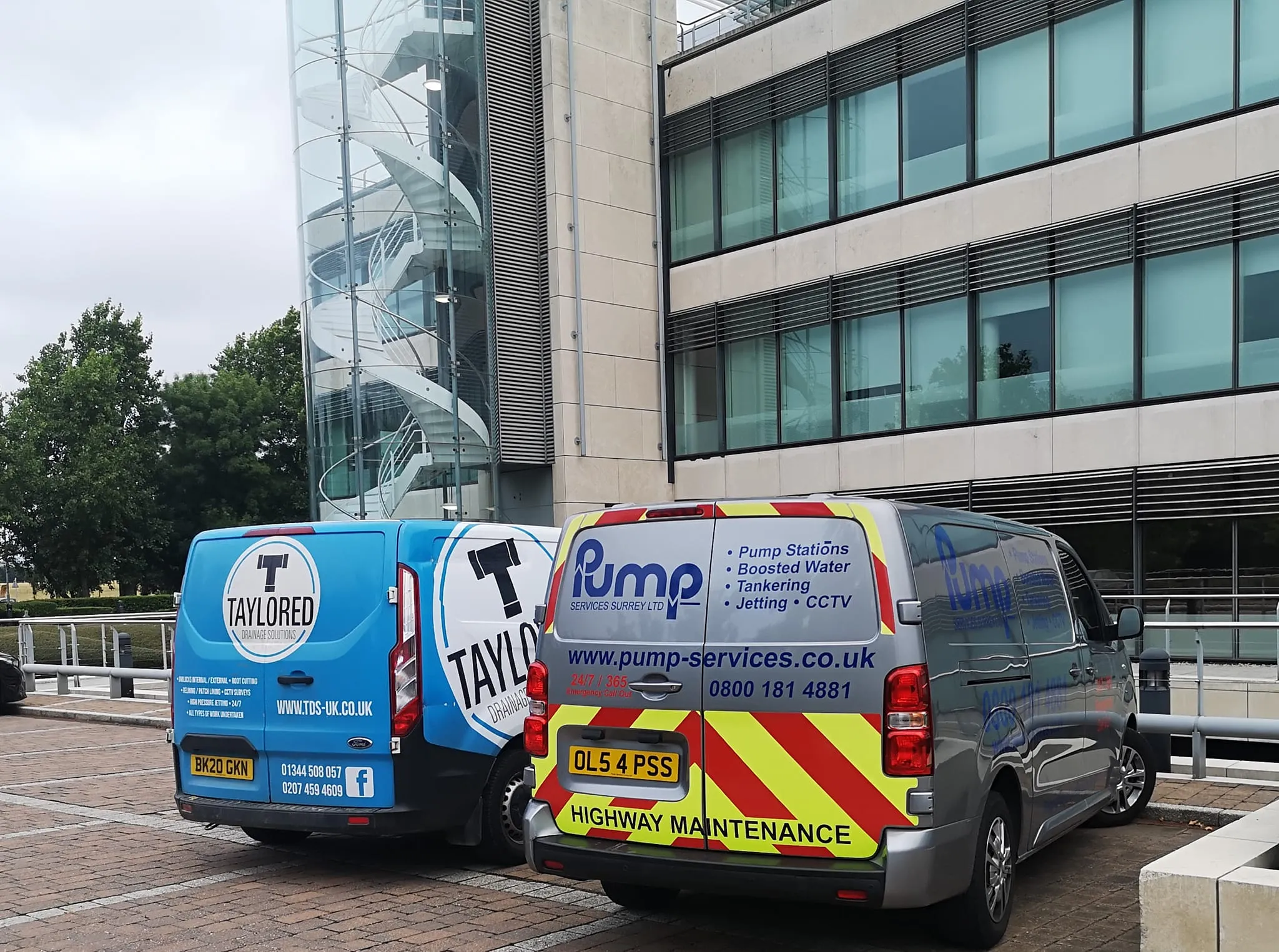 A couple of vans parked in front of a building.