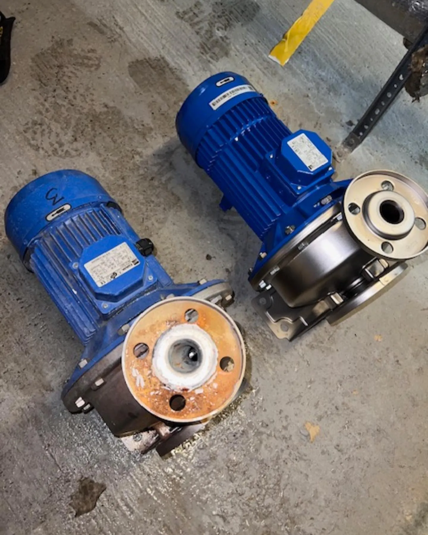 A couple of blue pumps sitting on top of a cement floor.