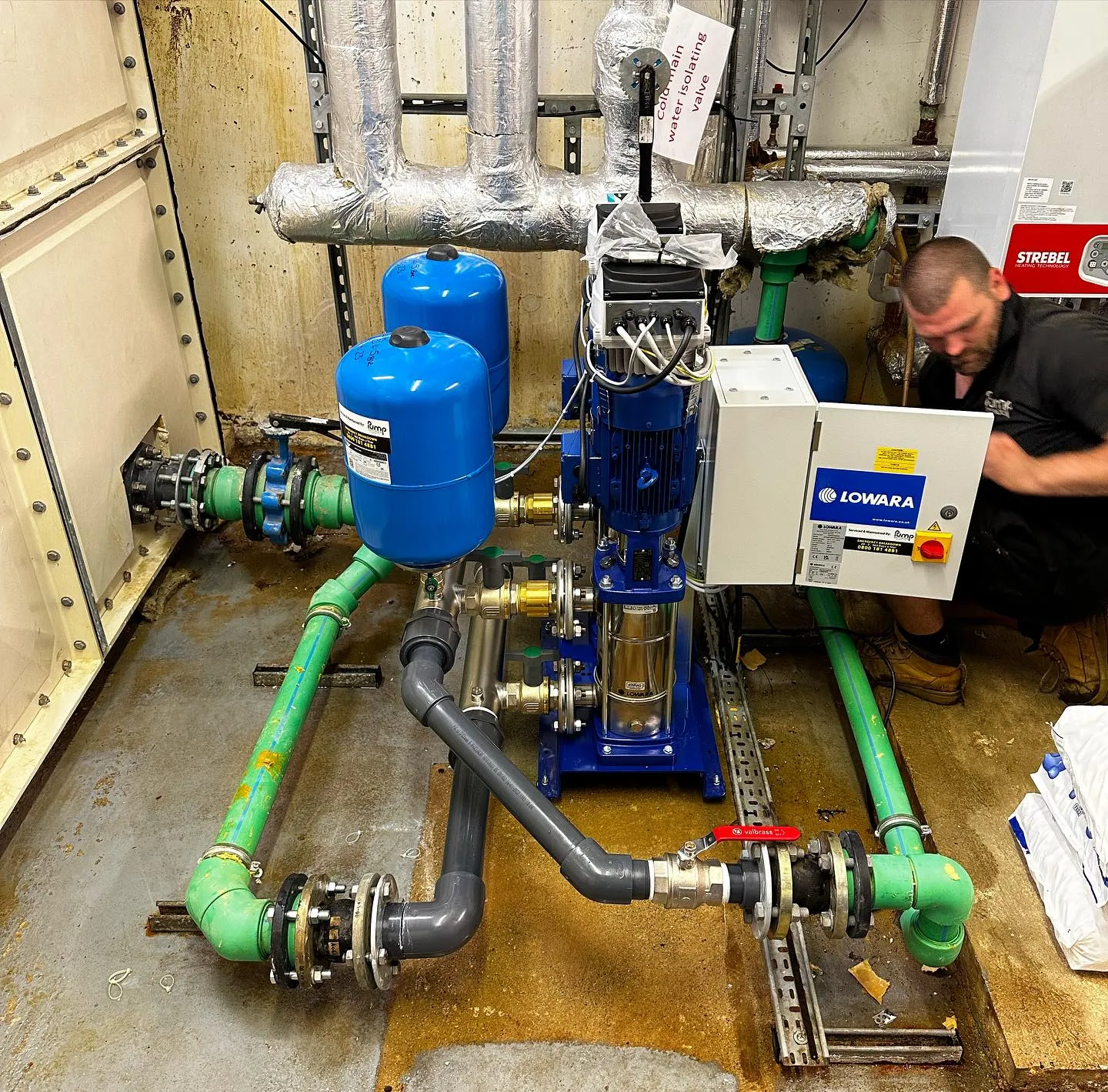 A man working on a machine inside of a building.